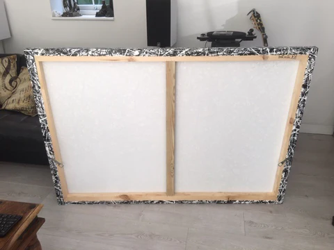 Back view of a canvas that has been stretched on to a wooden stretcher frame