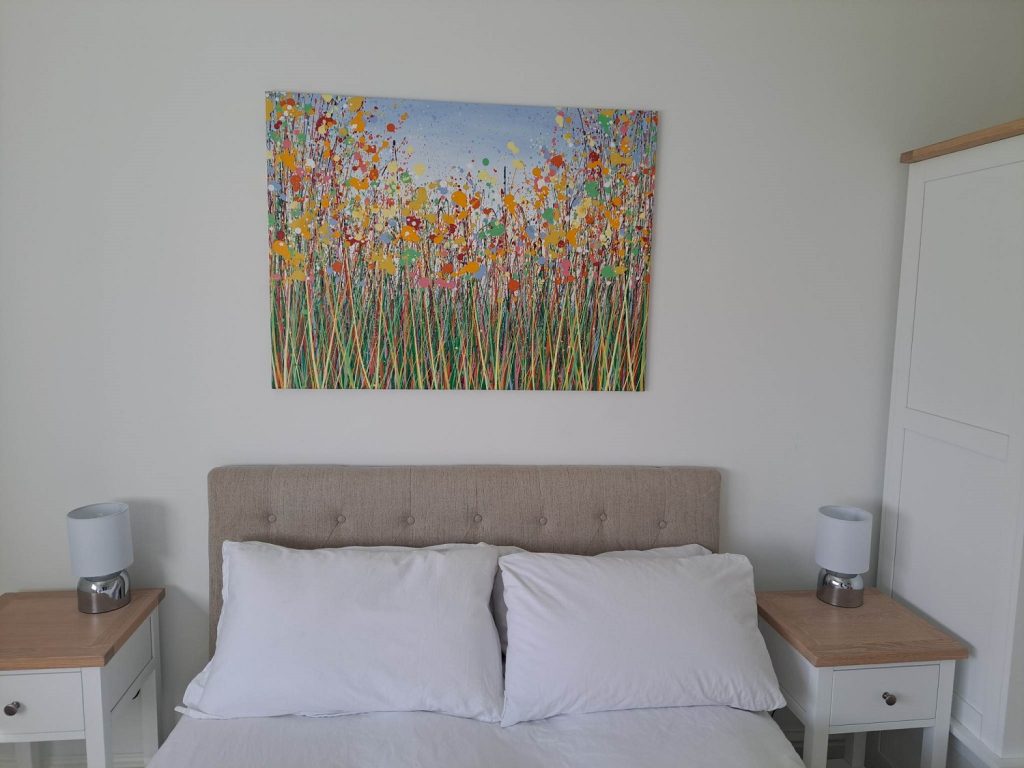 Customer showcase photo sent to me showing my original large yellow flower meadow painting on display in her home