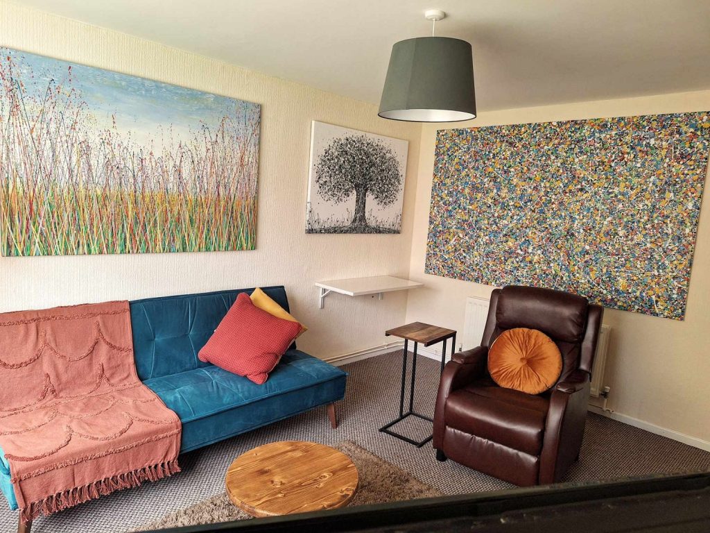 Customer showcase photo of three of my large abstract paintings on display in his lounge