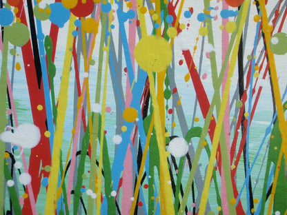 A colourful abstract painting of a grassy field with splattered flowers in orange, yellow, blue, and white against a light blue sky, hand-painted on to a large framed 100 by 70 cm canvas - detail