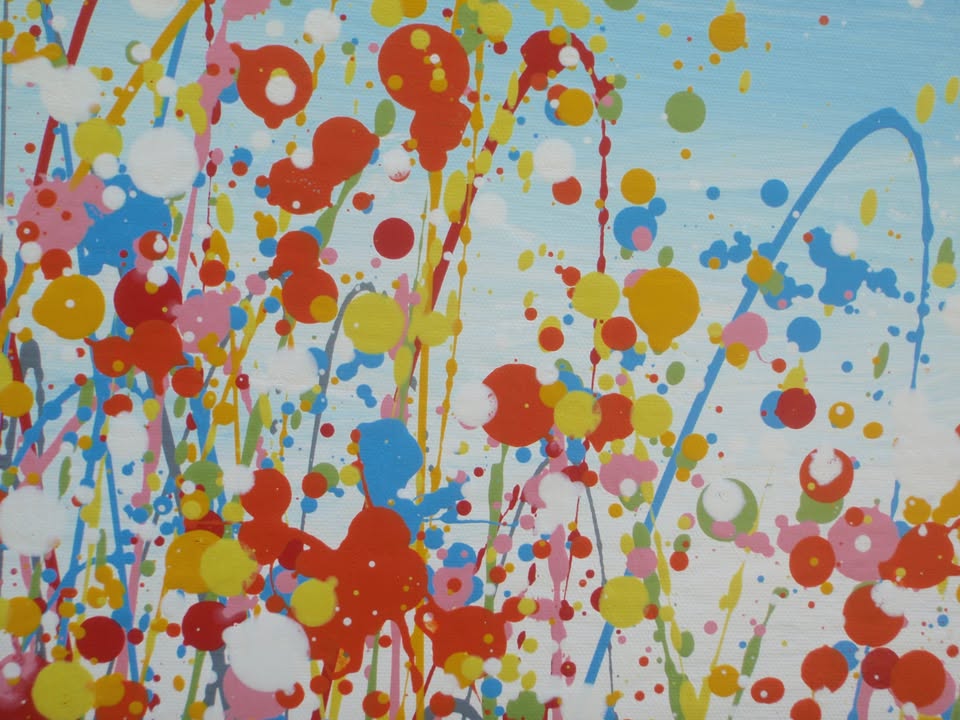 A colourful abstract painting of a grassy field with splattered flowers in orange, yellow, blue, and white against a light blue sky, hand-painted on to a large framed 100 by 70 cm canvas - detail