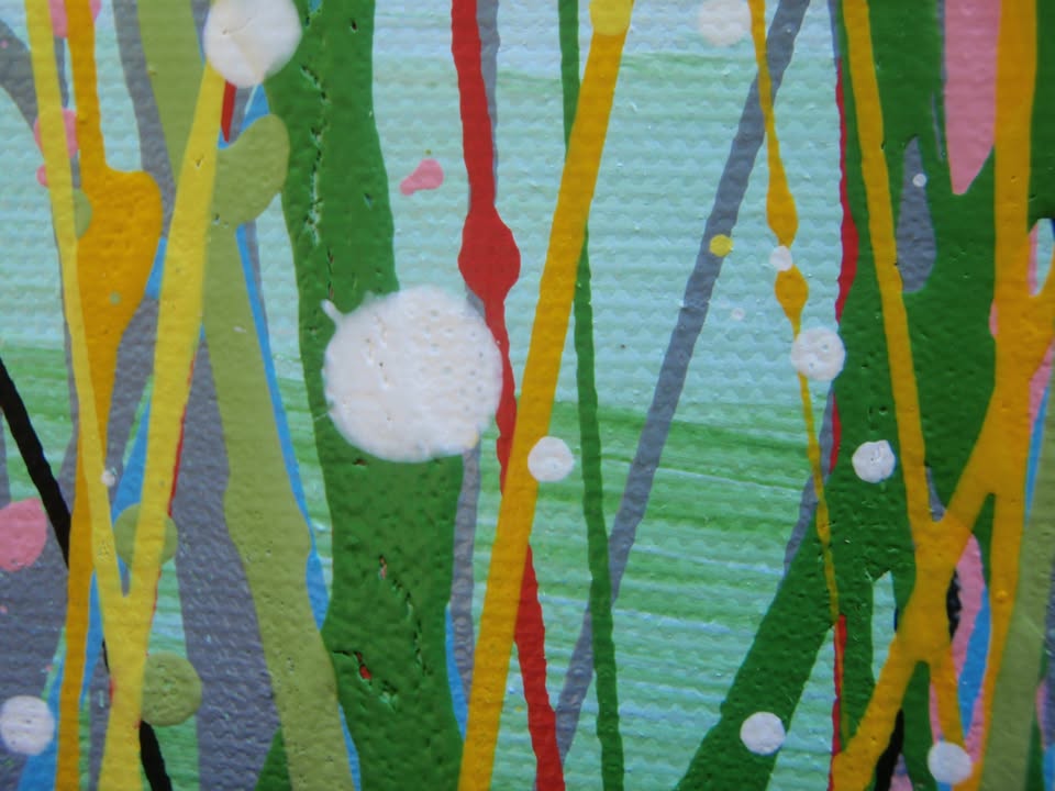 A colourful abstract painting of a grassy field with splattered flowers in orange, yellow, blue, and white against a light blue sky, hand-painted on to a large framed 100 by 70 cm canvas - detail