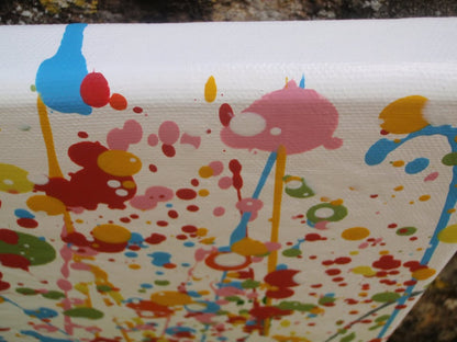 Abstract floral field painting with green grass-like strokes and many red, yellow, blue, and pink flower-like splatters on a white background - detail