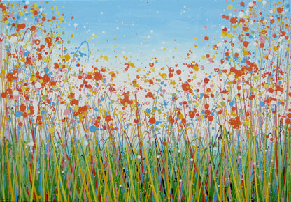 A colourful abstract painting of a grassy field with splattered flowers in orange, yellow, blue, and white against a light blue sky, hand-painted on to a large framed 100 by 70 cm canvas - full view