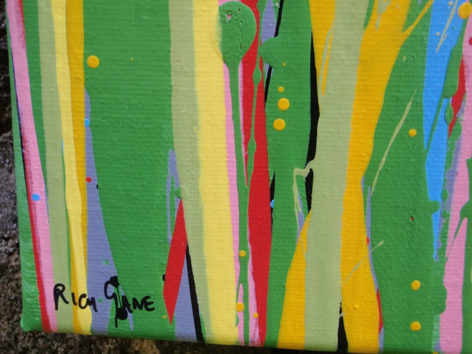 A colourful abstract painting of a grassy field under a blue sky, with splashes of pink, yellow, blue, green, and orange dots and lines throughout, hand-painted on to a large canvas - detail