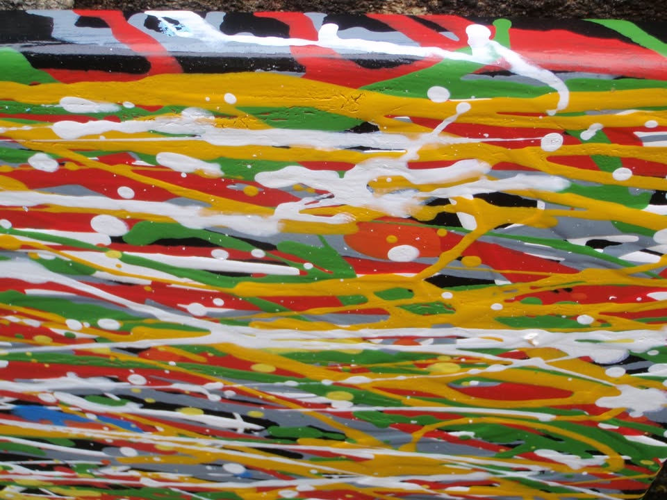 A full-frame abstract artwork composed of dense, horizontal multicoloured drips and textured lines in blue, yellow, red, orange, white, and green - detail