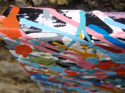 Unique abstract radial artwork filled with dense splatters and streaks of blue, red, orange, yellow, black, and white radiating from a bright white centre, on a 150 by 100 cm framed canvas - detail