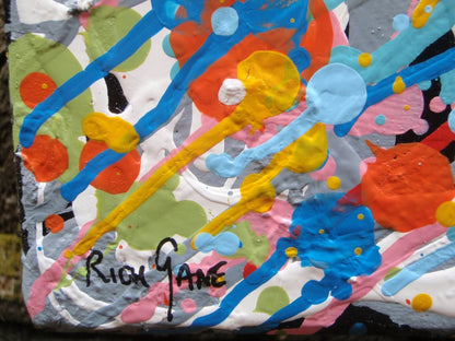 Unique abstract radial artwork filled with dense splatters and streaks of blue, red, orange, yellow, black, and white radiating from a bright white centre, on a 150 by 100 cm framed canvas - detail