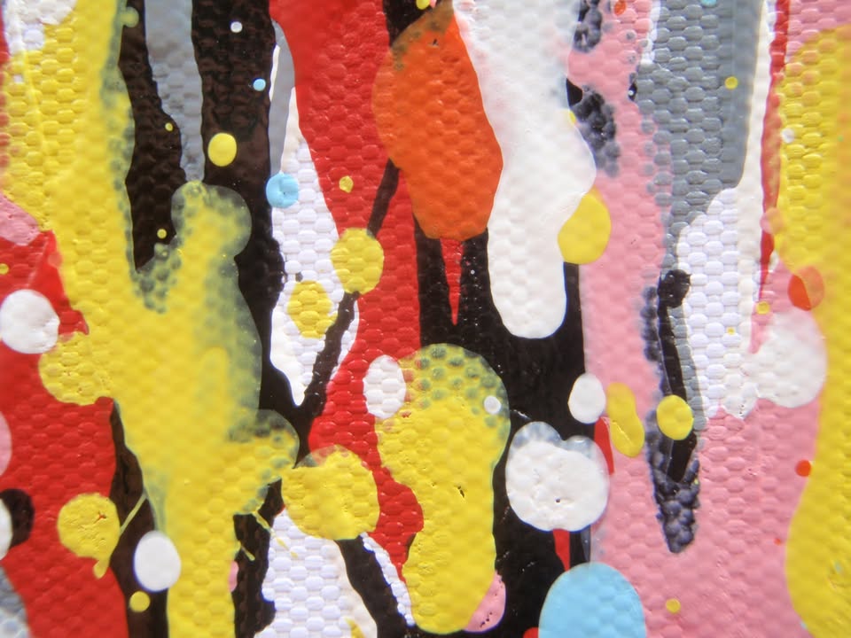 Abstract vertical drip painting with a dense field of multicoloured paint drips in orange, yellow, red, blue, and white on a white canvas - detail
