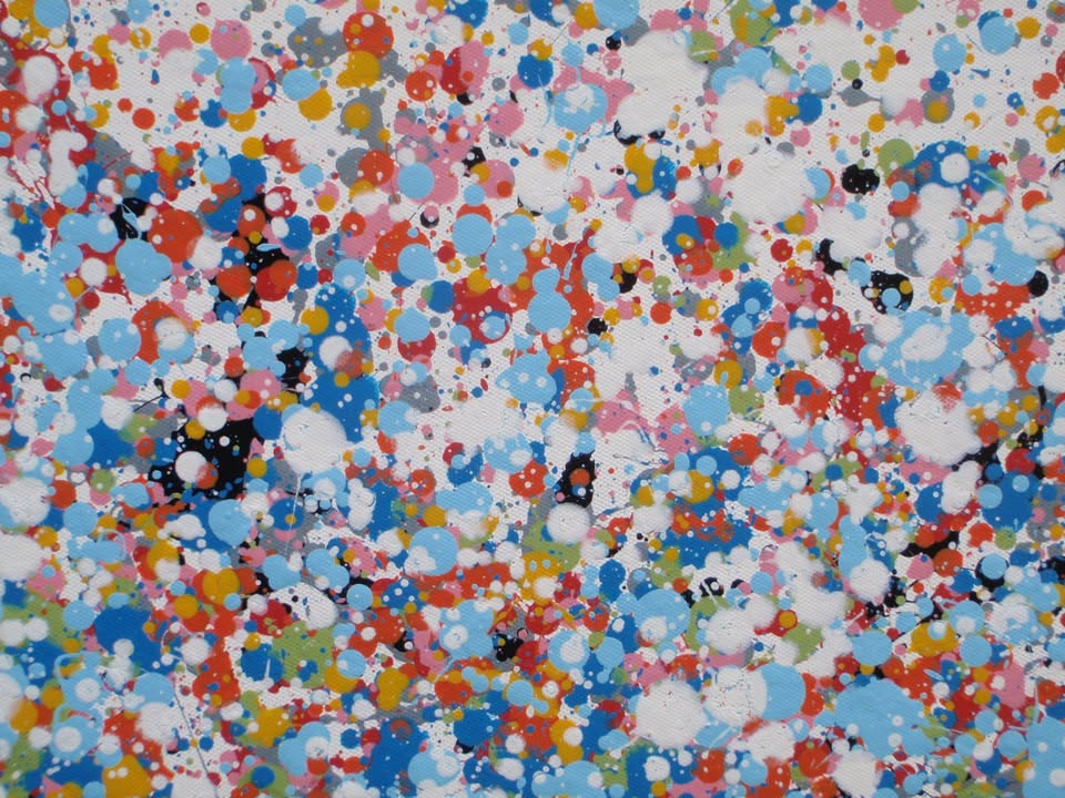 A rectangular abstract art painting featuring a dense seascape of multicoloured speckles, with a prominent horizontal band of white and light blue in the centre and denser blue speckling around the edges. Hand-painted on to a 250 by 112 cm un-stretched canvas. Detail.