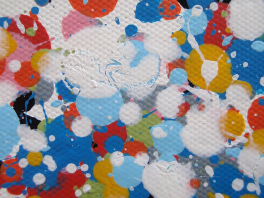 A rectangular abstract art painting featuring a dense seascape of multicoloured speckles, with a prominent horizontal band of white and light blue in the centre and denser blue speckling around the edges. Hand-painted on to a 250 by 112 cm un-stretched canvas. Detail.