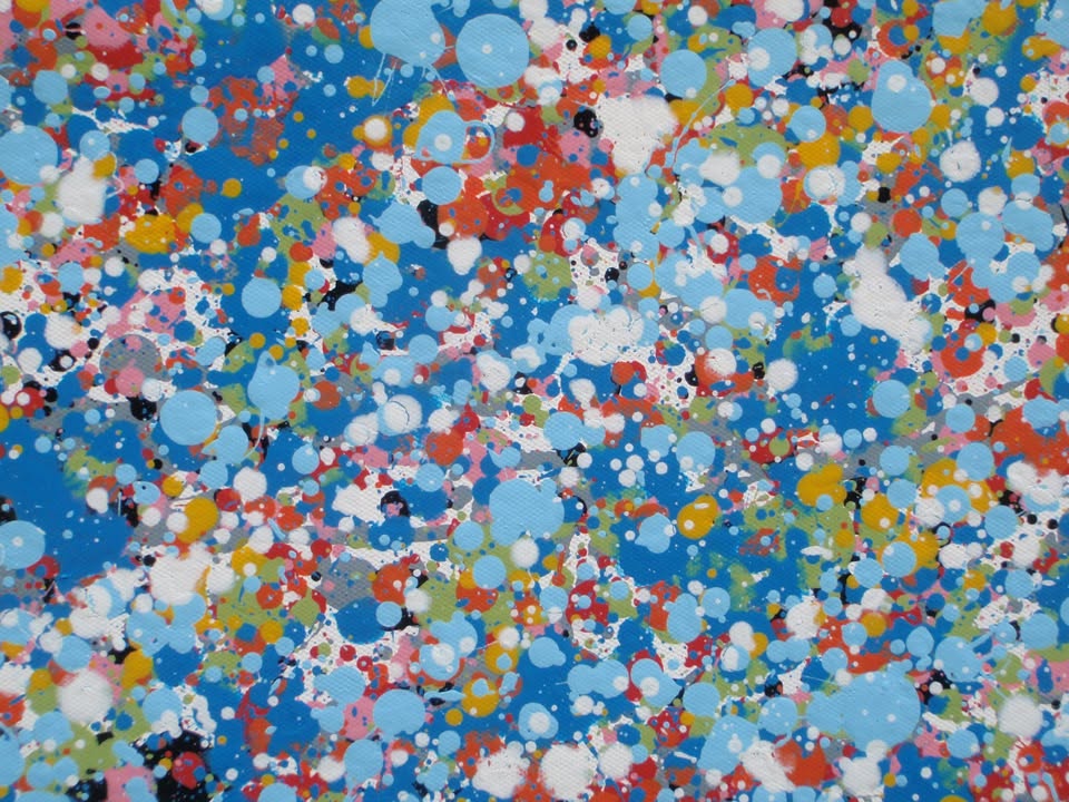A rectangular abstract art painting featuring a dense seascape of multicoloured speckles, with a prominent horizontal band of white and light blue in the centre and denser blue speckling around the edges. Hand-painted on to a 250 by 112 cm un-stretched canvas. Detail.