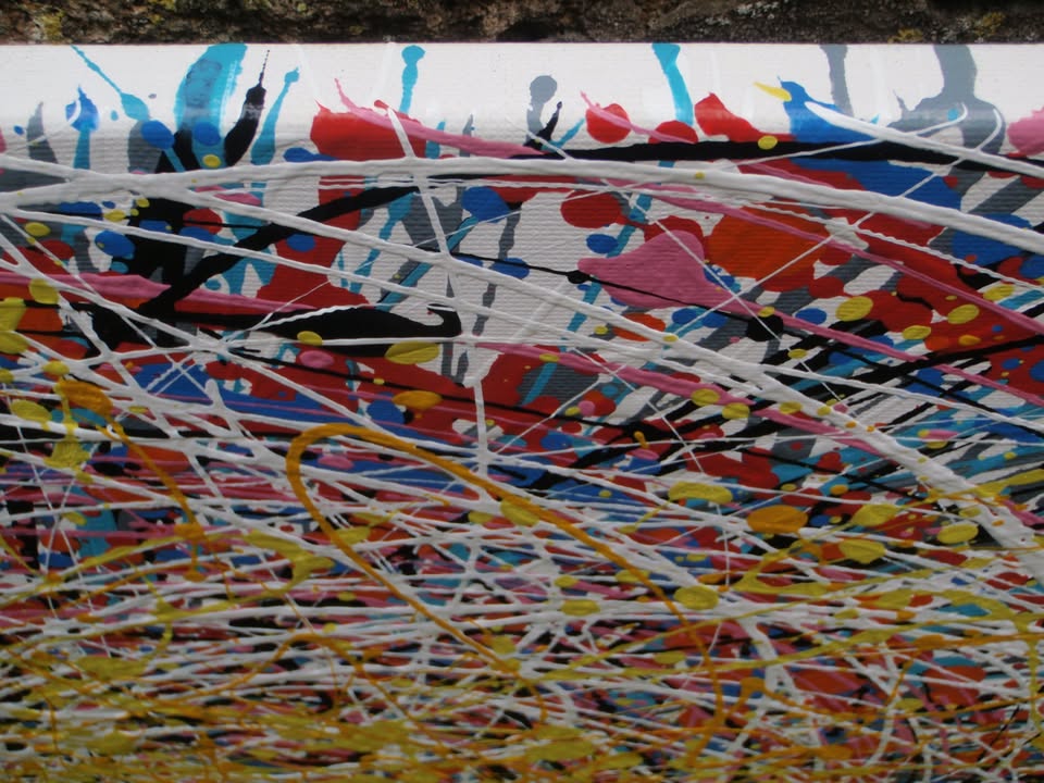 Abstract expressionist painting featuring a dense, circular composition of energetic splatters, drips, and intersecting lines in yellow, white, red, blue, black, and orange. Hand-painted by me, Rich Gane, on to a large, framed, 80 by 60 cm canvas - detail