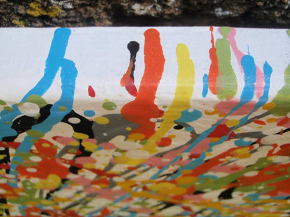 Abstract radial burst painting with dense splatters and streaks of yellow, orange, white, blue, pink, red, and green radiating outward from a bright central area, on 80 by 60 cm canvas - detail