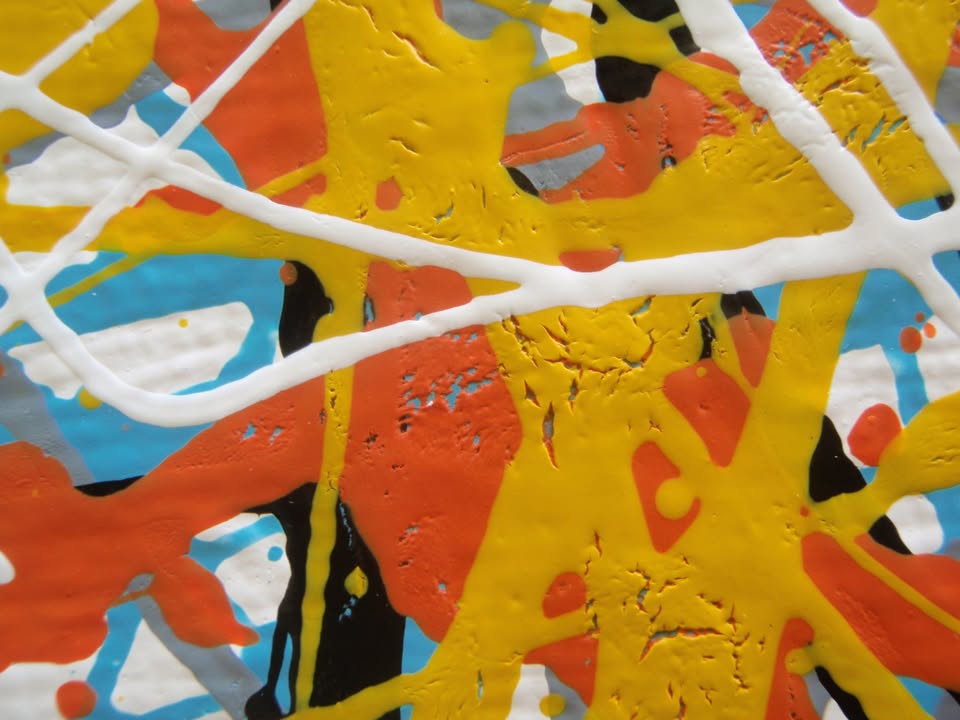 An abstract painting filled with dense, energetic splatters and drips in orange, yellow, white, black, and light blue, hand-painted on to a large framed wooden panel - detail