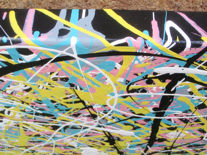 Abstract canvas art 150 by 100 cm painting featuring a dense, expressive composition of overlapping black, yellow, blue, pink, and white paint splatters and scribbles on a dark background - detail