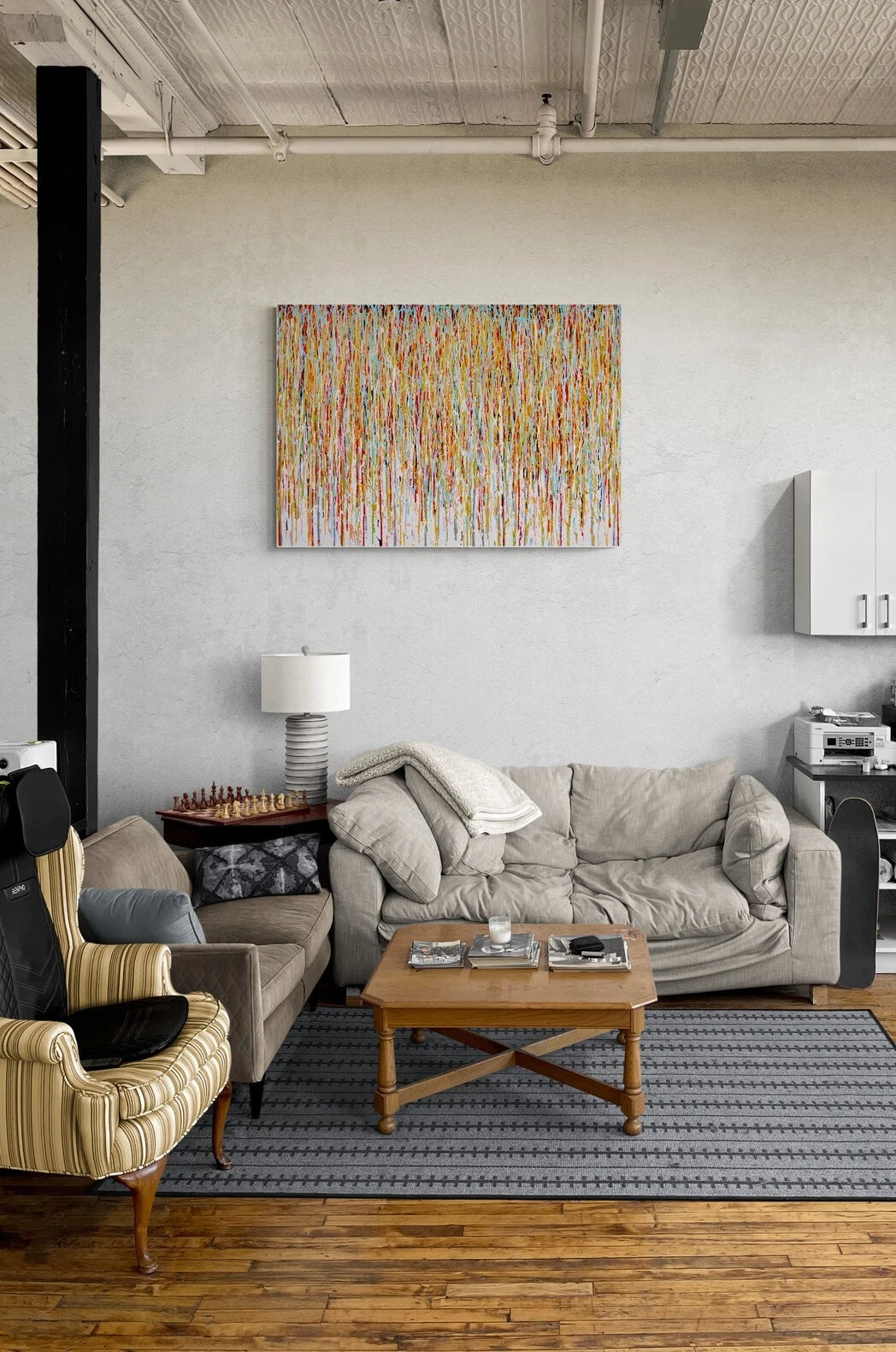 Living room with grey sofa, wooden coffee table, and a large abstract painting on wall with vertical lines and stripes