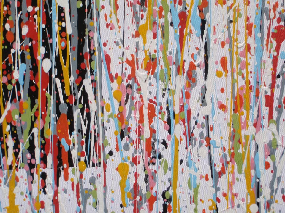 Abstract wall art featuring the word 'JOY' formed by dripping, splattered paint in multiple colours including red, blue, yellow, black, and white on a light background - detail