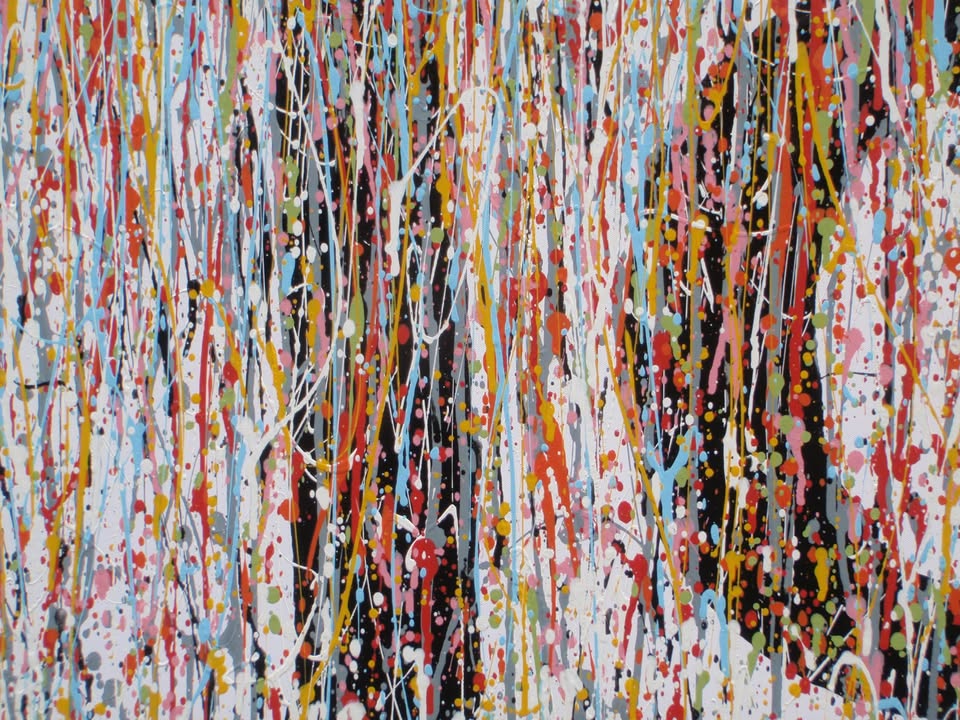 Abstract wall art featuring the word 'JOY' formed by dripping, splattered paint in multiple colours including red, blue, yellow, black, and white on a light background - detail